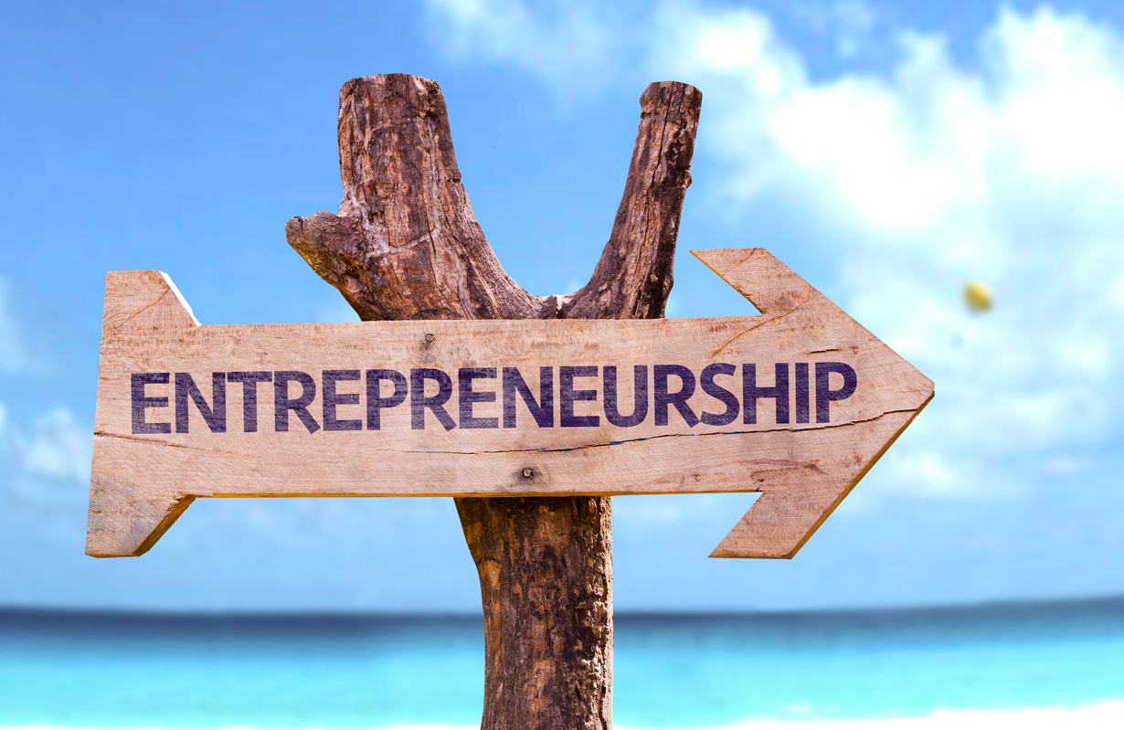 Entrepreneurship wooden sign with a beach background